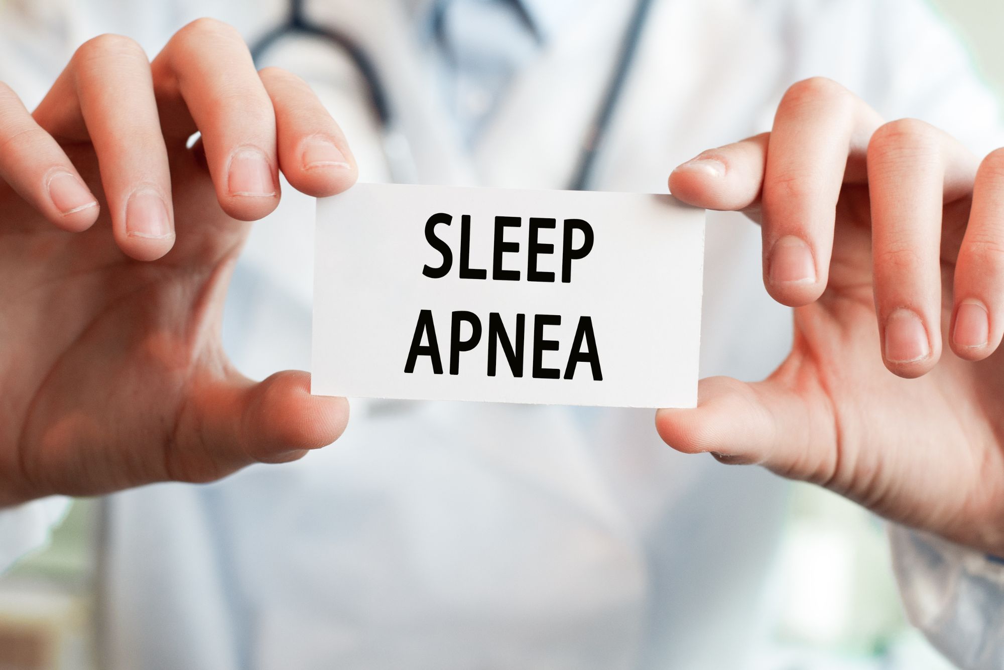 A person holding a card that says sleep apnea, and wondering if sleep apnea is genetic/hereditary.