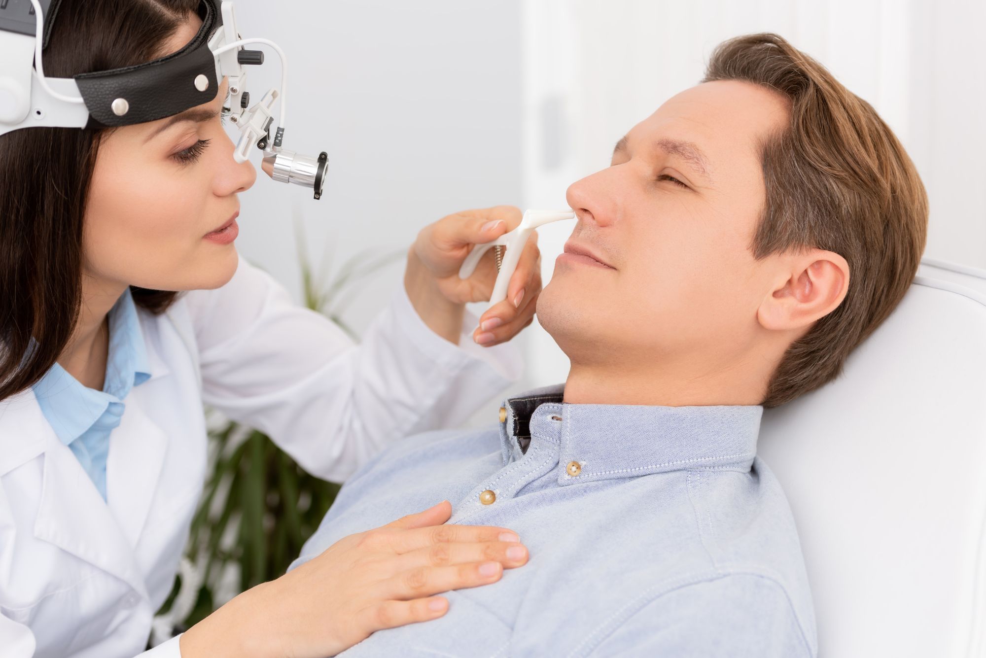 A ENT doctor seeing examining a patient's nose and determining if he needs turbinate surgery or VivAer.