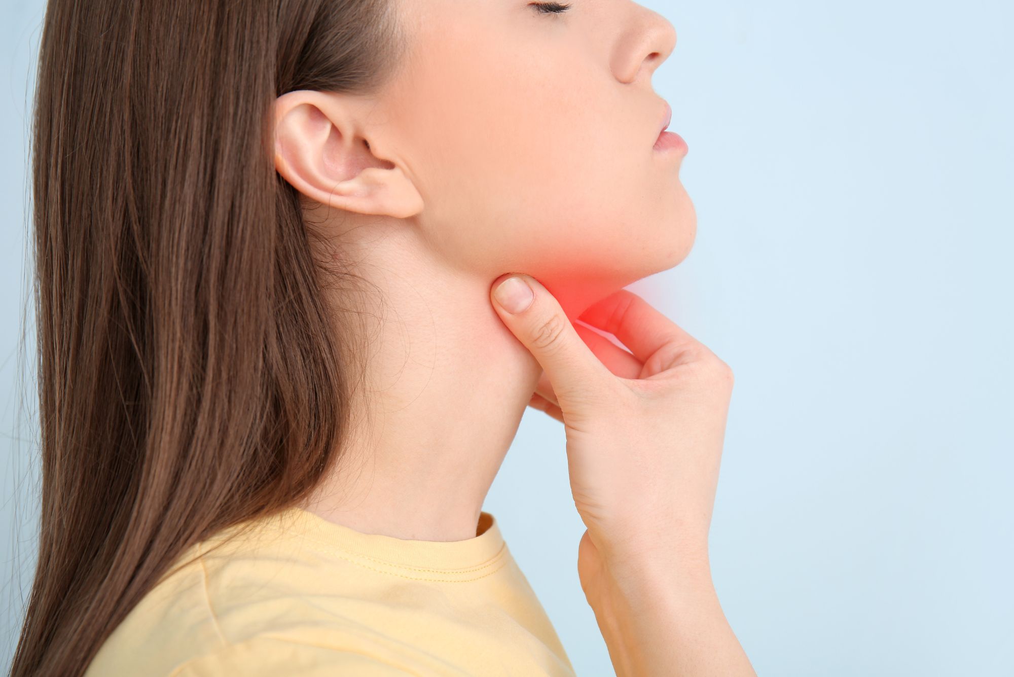 A woman holds her throat when trying to figure out if she needs to worry about her thyroid nodules.