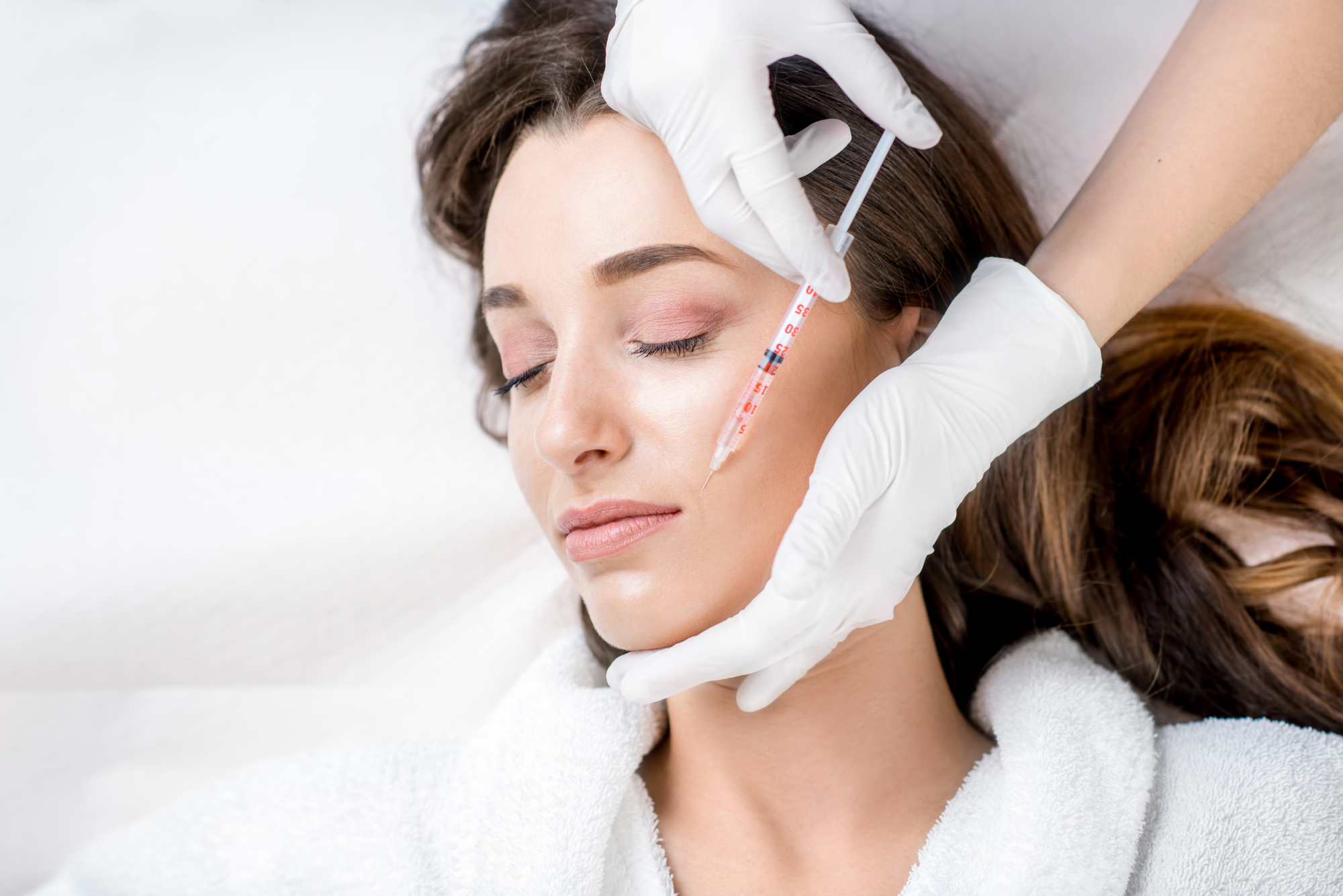 A woman gets a botox treatment done after learning about the risks of bruising after botox.