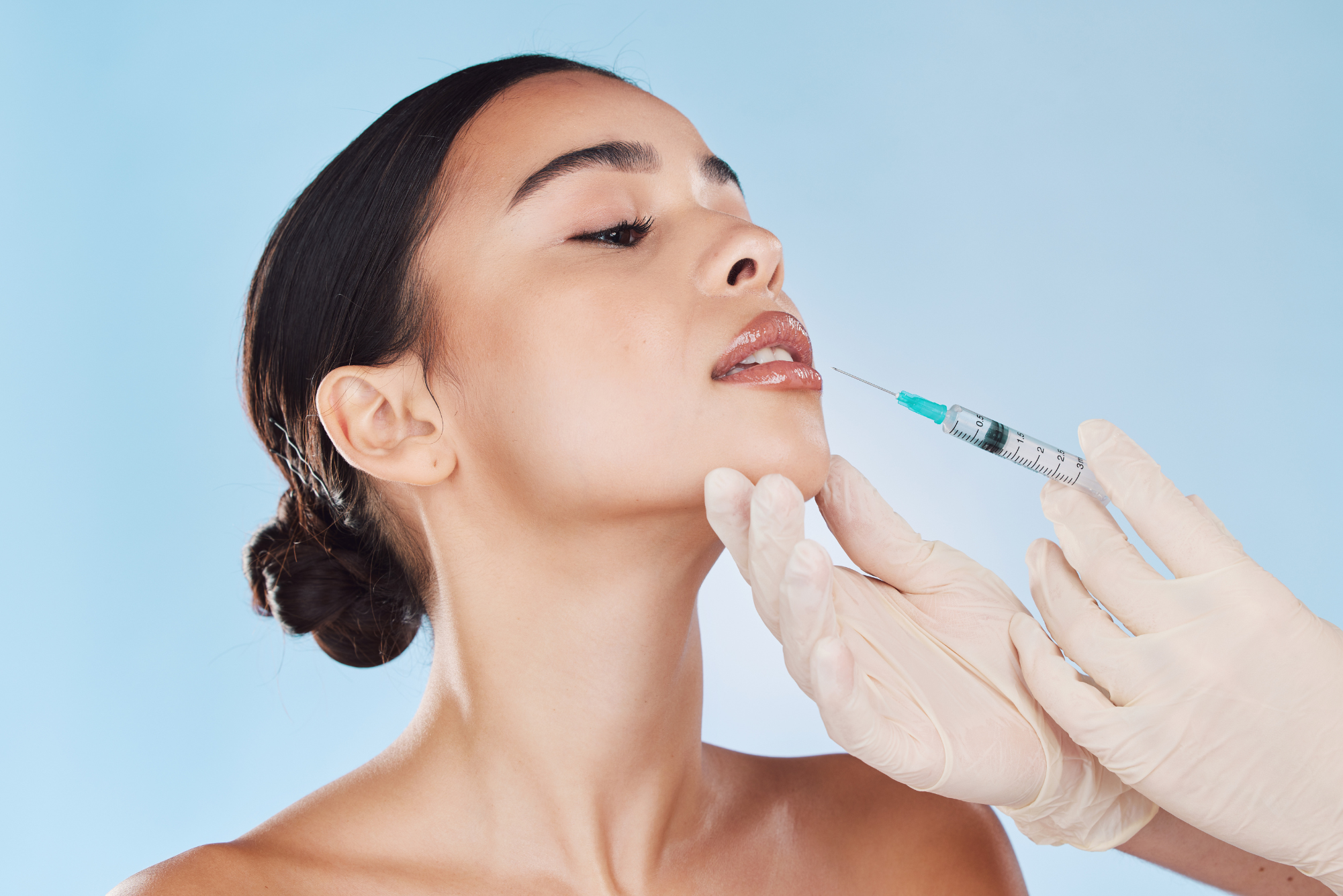 A dark-haired woman looks upwards a she’s about to receive a Botox treatment to help with her teeth grinding.